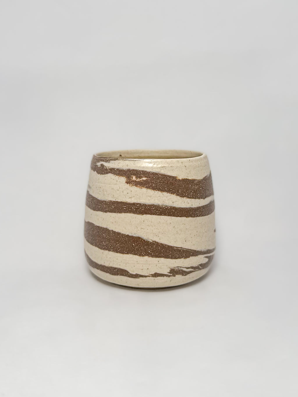 A marbled ceramic stoneware tumbler with brown and white clay